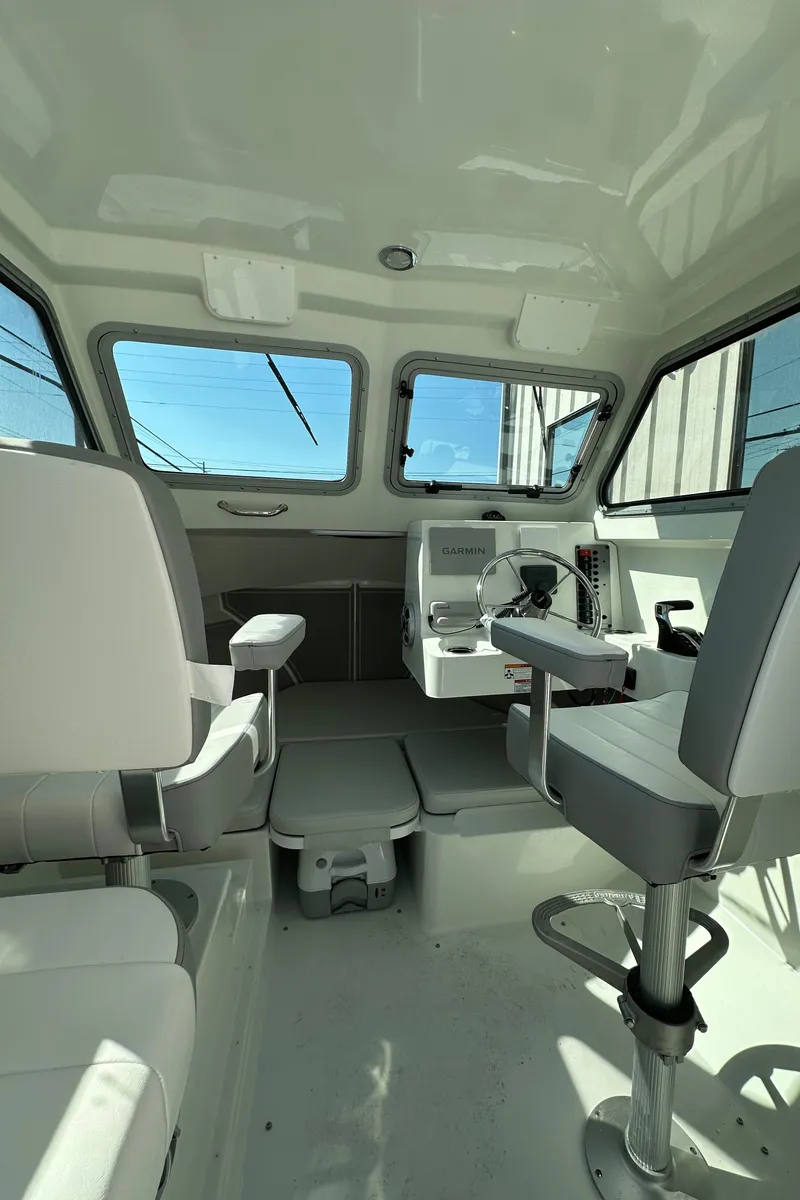Slide: The Image of Interior of 2025 Parker 2420 Sport Cabin boat with modern seating and navigation equipment. - 4