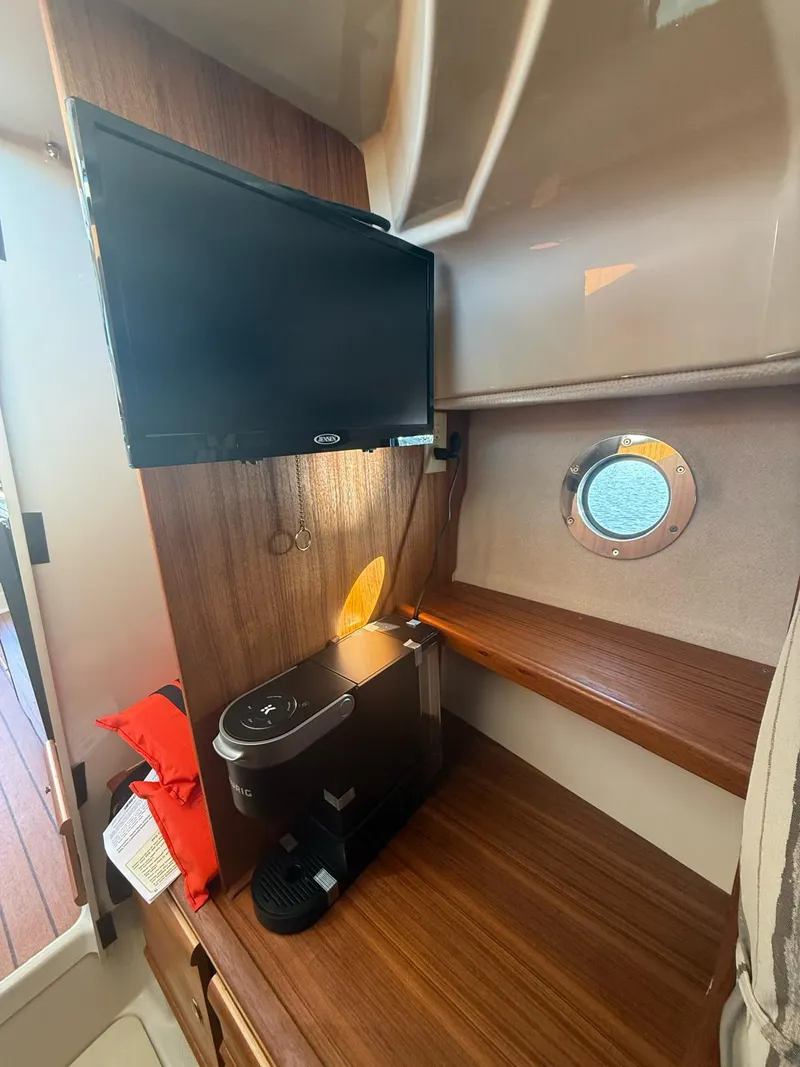 Slide: The Image of Interior of 2023 Ranger Tugs R-27 with TV, coffee maker, and porthole window. - 11