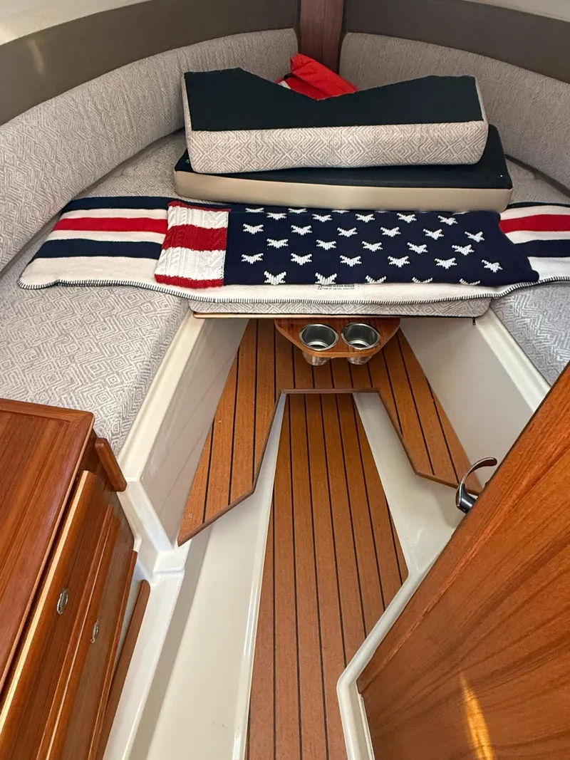 Slide: The Image of 2023 Ranger Tugs R-27 cabin interior with wooden flooring and cozy bedding. - 12