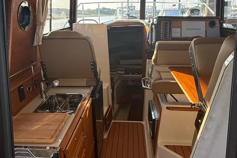 Slide: The Image of Interior of 2023 Ranger Tugs R-27 boat with kitchen and seating area. - 16