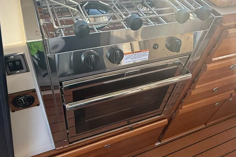 Slide: The Image of 2023 Ranger Tugs R-27 kitchen with stainless steel stove and oven. - 17