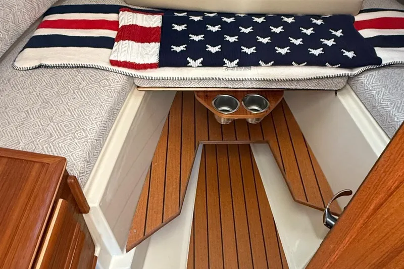 Slide: The Image of 2023 Ranger Tugs R-27 interior with American flag-themed decor and wooden flooring. - 19