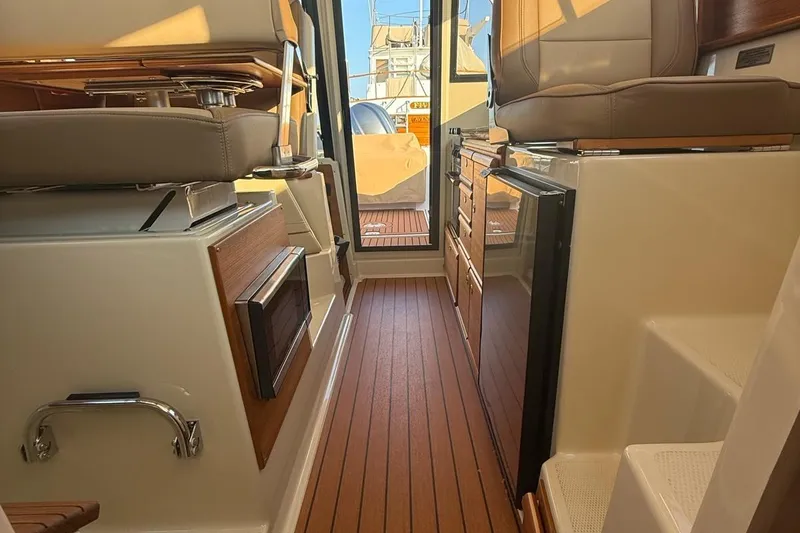Slide: The Image of Interior of 2023 Ranger Tugs R-27, featuring wood flooring and modern seating. - 20