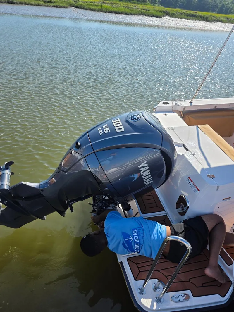 Slide: The Image of Man inspecting Yamaha outboard motor on 2023 Ranger Tugs R-27 boat. - 5