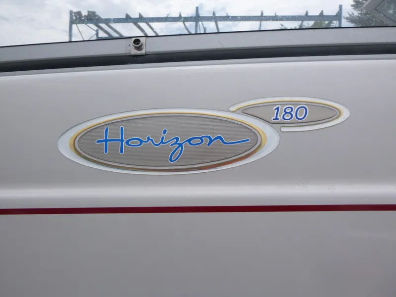 Slide: The Image of 2004 Four Winns 180 Horizon boat logo on white surface. - 13