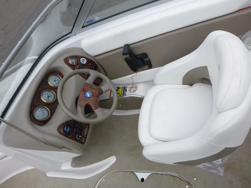 Slide: The Image of 2004 Four Winns 180 Horizon boat cockpit with steering wheel and white captain's chair. - 6