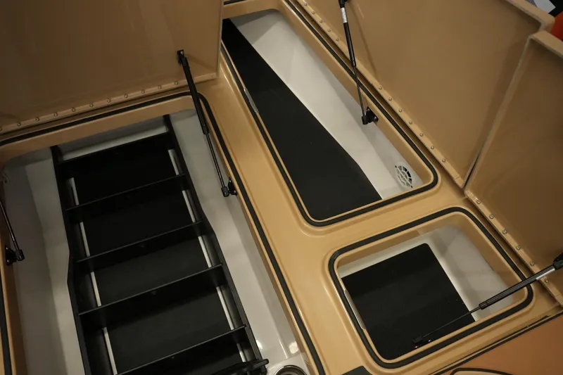 Slide: The Image of 2025 Caymas XS 20 PRO boat interior with tan seats and storage compartments. - 8