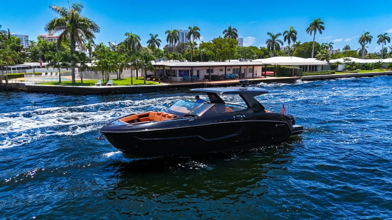 The Image of 2022 Cruisers Yachts 38 GLS on a sunny day, cruising near palm-lined waterfront. - 0