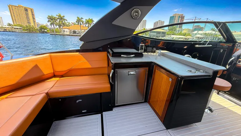 Slide: The Image of Luxurious 2022 Cruisers Yachts 38 GLS interior with seating and kitchenette by the water. - 12