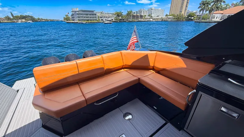 Slide: The Image of Luxurious 2022 Cruisers Yachts 38 GLS with tan seating, docked by scenic waterfront. - 11