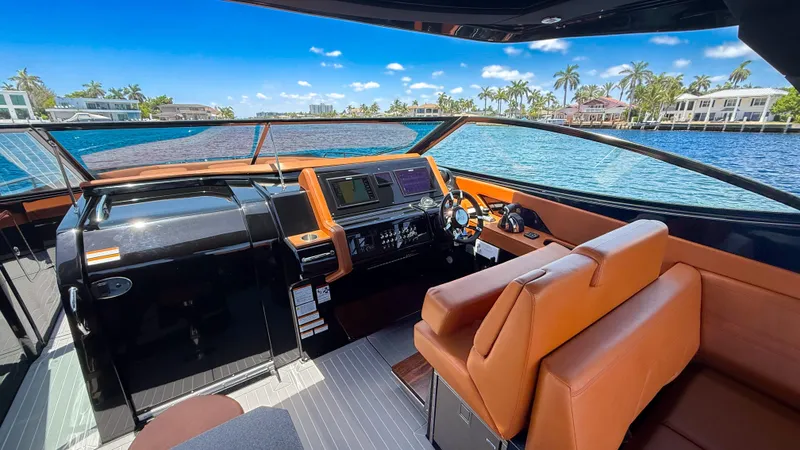 Slide: The Image of 2022 Cruisers Yachts 38 GLS helm with luxurious seating and modern controls, overlooking serene waters. - 13