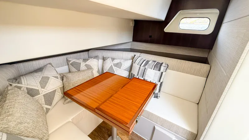 Slide: The Image of 2022 Cruisers Yachts 38 GLS interior with cozy seating and wooden table. - 16