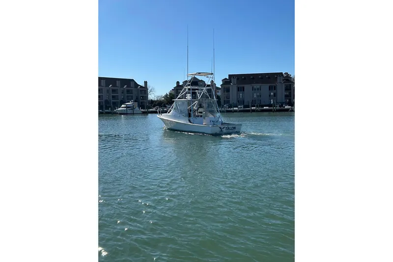 Slide: The Image of 1992 Blue Fin 36 Express boat cruising in a marina with waterfront buildings. - 4