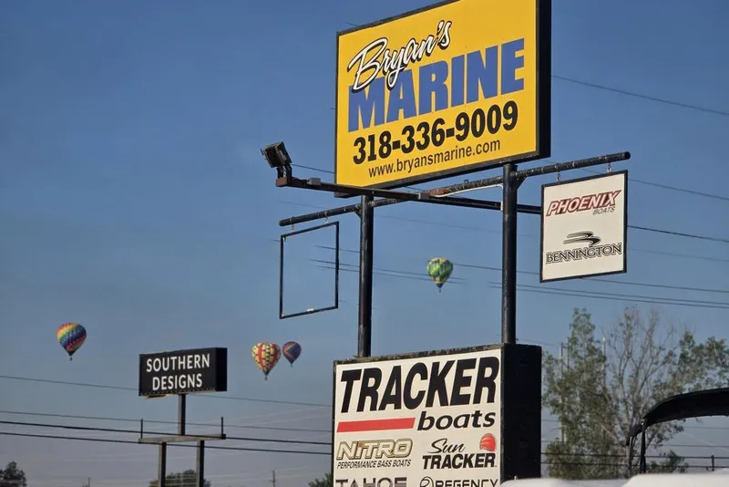 Slide: The Image of Bryan's Marine signage with hot air balloons in the background, clear blue sky. - 12