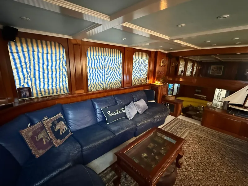 Slide: The Image of Luxurious 1971 Broward Motor Yacht interior with blue sofa and striped curtains. - 11
