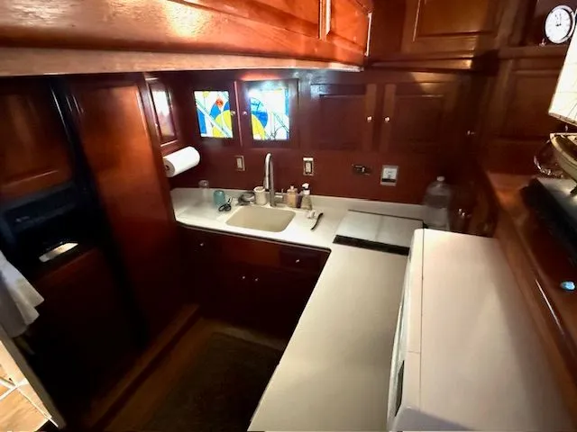 Slide: The Image of 1971 Broward Motor Yacht kitchen with wooden cabinets and stained glass windows. - 13