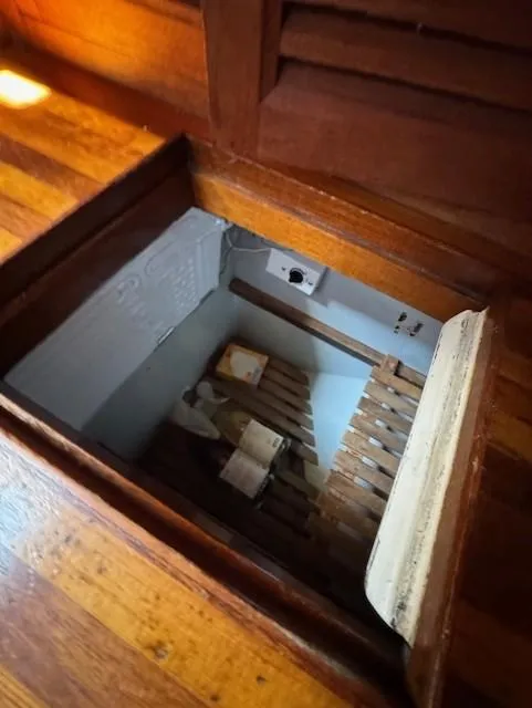 Slide: The Image of Wooden hatch opening on a 1978 Baba 30 boat, revealing storage space below deck. - 17