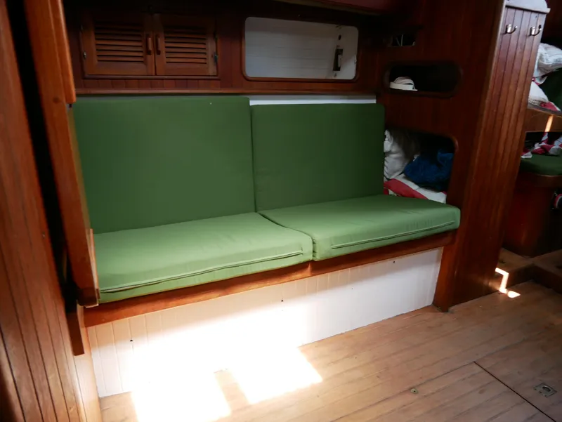 Slide: The Image of Interior of a 1978 Baba 30 sailboat with green cushioned seating. - 23