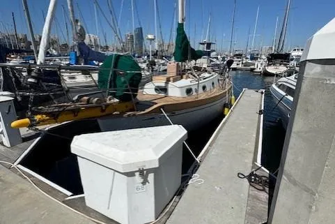 Slide: The Image of 1978 Baba 30 sailboat docked in a marina, surrounded by other boats under a clear blue sky. - 33