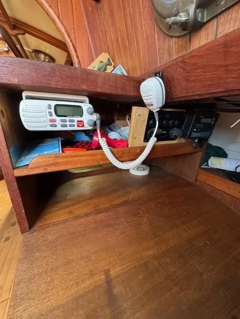 Slide: The Image of Wooden interior of a 1978 Baba 30 boat with radio equipment and storage shelves. - 8