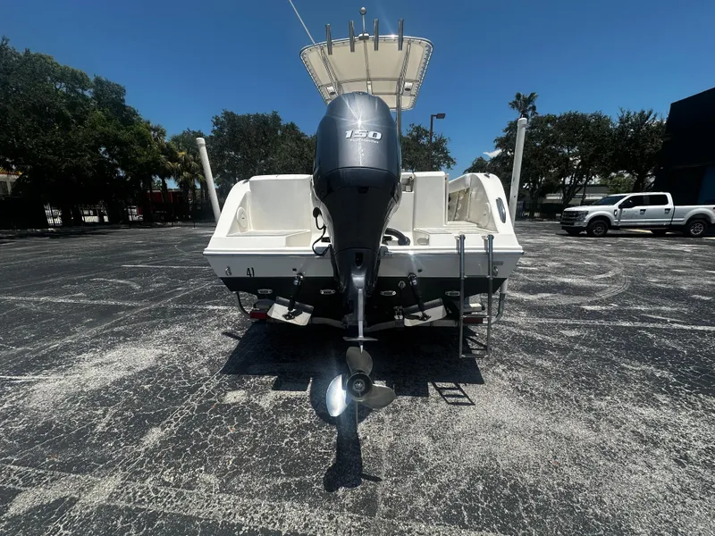 Slide: The Image of 2019 Cobia 220 boat with 150 HP outboard motor in a parking lot. - 3