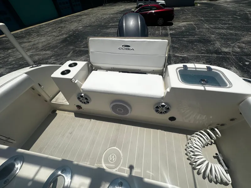 Slide: The Image of 2019 Cobia 220 boat interior with seating, speakers, and storage compartments. - 5