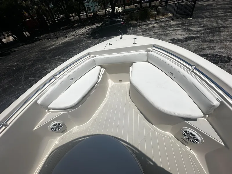 Slide: The Image of 2019 Cobia 220 boat interior with white cushioned seating and speakers. - 6