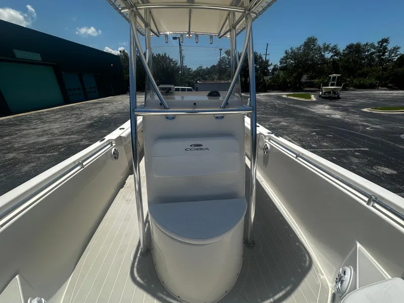 Slide: The Image of 2019 Cobia 220 boat interior with center console and T-top under clear sky. - 7