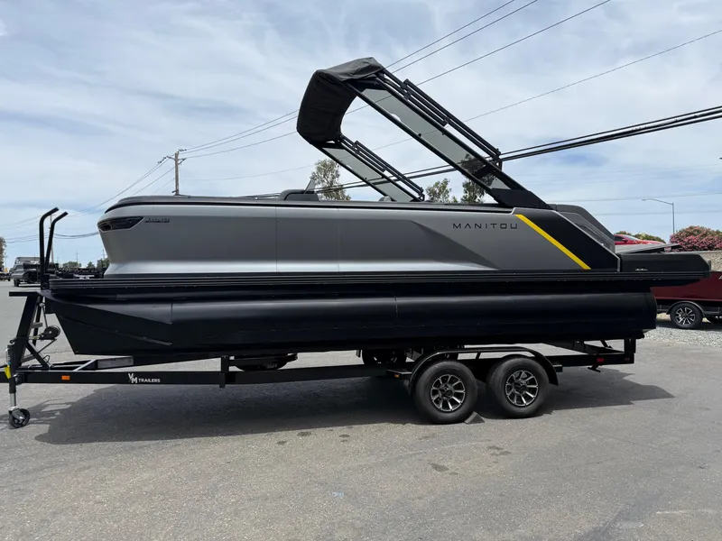 Slide: The Image of 2025 Manitou Explore pontoon boat on trailer, sleek design, gray and black color scheme. - 4
