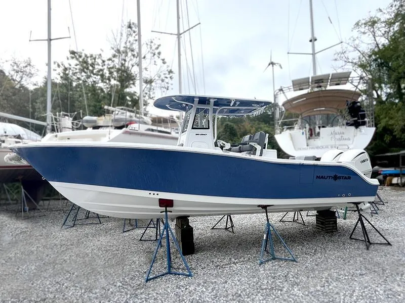 Slide: The Image of 2025 NauticStar 292 Legacy boat in a boatyard, elevated on stands. - 12