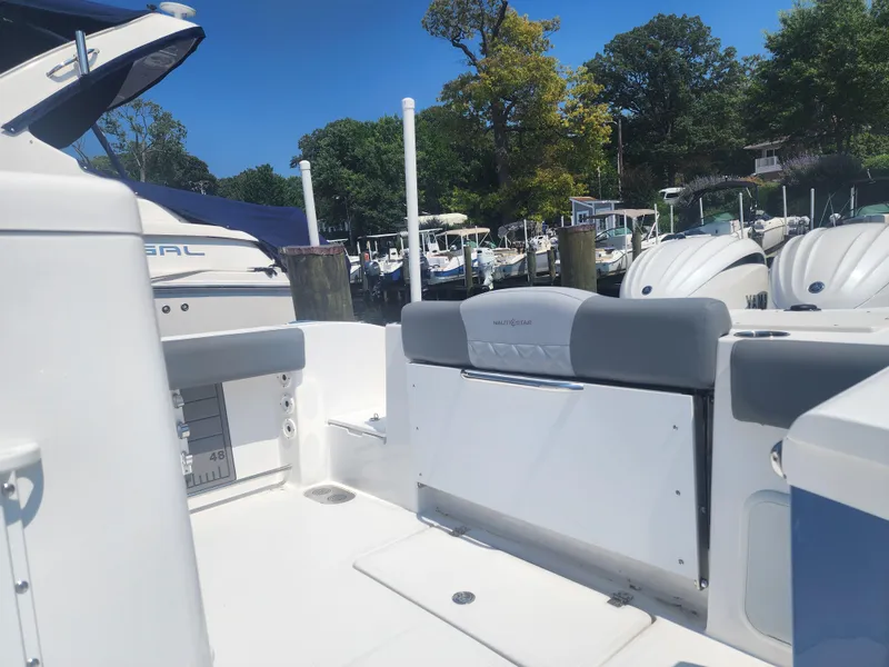 Slide: The Image of 2025 NauticStar 292 Legacy boat interior at marina, featuring sleek seating and modern design. - 3