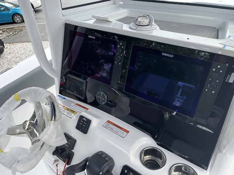 Slide: The Image of 2025 NauticStar 292 Legacy boat dashboard with dual Simrad displays and steering wheel. - 5