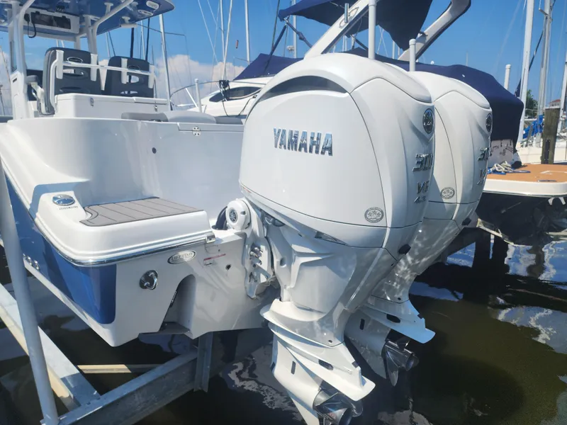 Slide: The Image of 2025 NauticStar 292 Legacy boat with dual Yamaha outboard engines at a marina. - 9