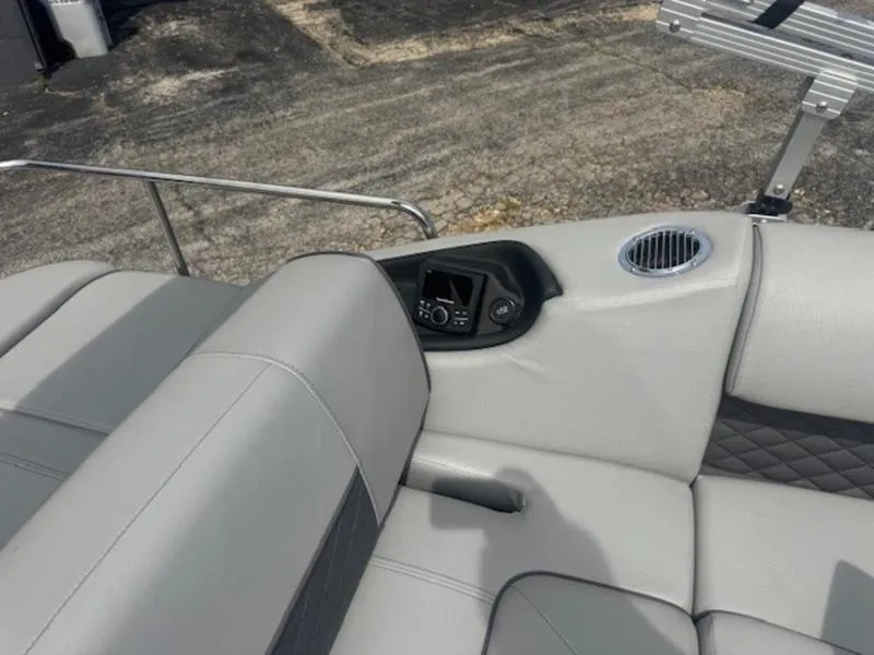 Slide: The Image of 2025 Bennington L Bowrider Swingback 25 LTSB interior with gray seating and control panel. - 7