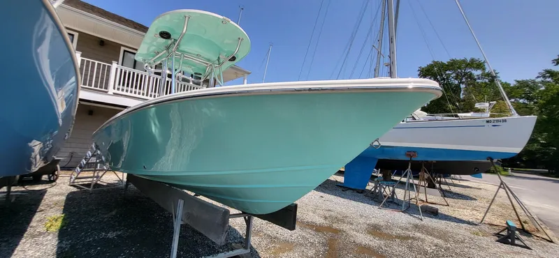 Slide: The Image of 2023 Sea Chaser 23 LX boat in a marina, light blue hull, sunny day. - 1