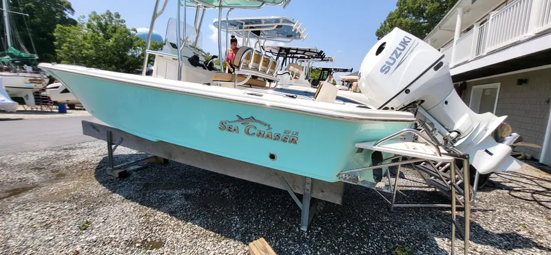 Slide: The Image of 2023 Sea Chaser 23 LX boat with Suzuki engine on display outdoors. - 11
