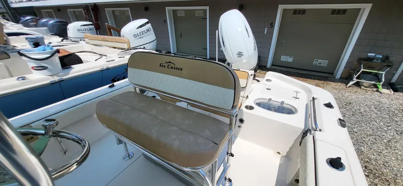 Slide: The Image of 2023 Sea Chaser 23 LX boat with Suzuki outboard engines, docked in a marina. - 14