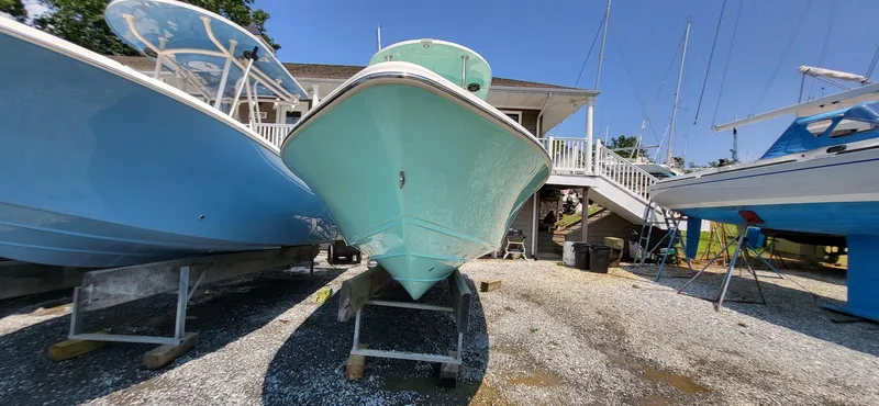 Slide: The Image of 2023 Sea Chaser 23 LX boat on display at a marina, surrounded by other boats. - 9