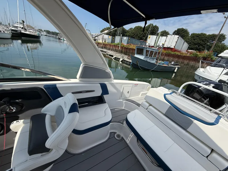 Slide: The Image of 2022 Chaparral 267 SSX OB boat interior at marina, featuring sleek seating and modern design. - 10