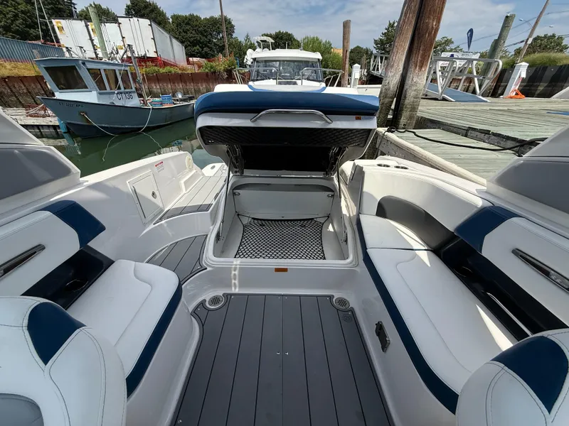 Slide: The Image of 2022 Chaparral 267 SSX OB boat interior with open storage compartment at dock. - 12