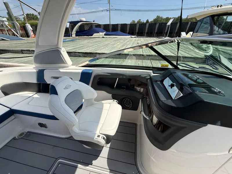 Slide: The Image of 2022 Chaparral 267 SSX OB boat interior with white seating and modern dashboard. - 17
