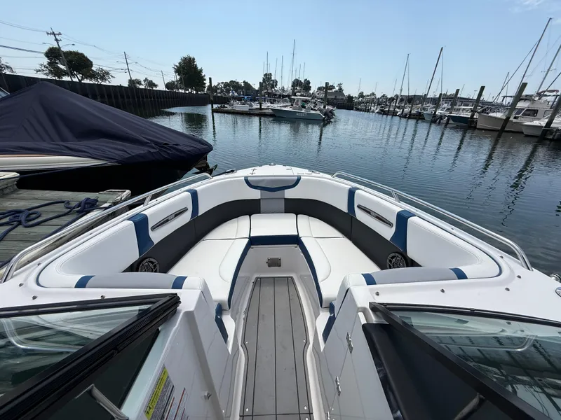 Slide: The Image of 2022 Chaparral 267 SSX OB boat interior at marina, featuring spacious seating and sleek design. - 24