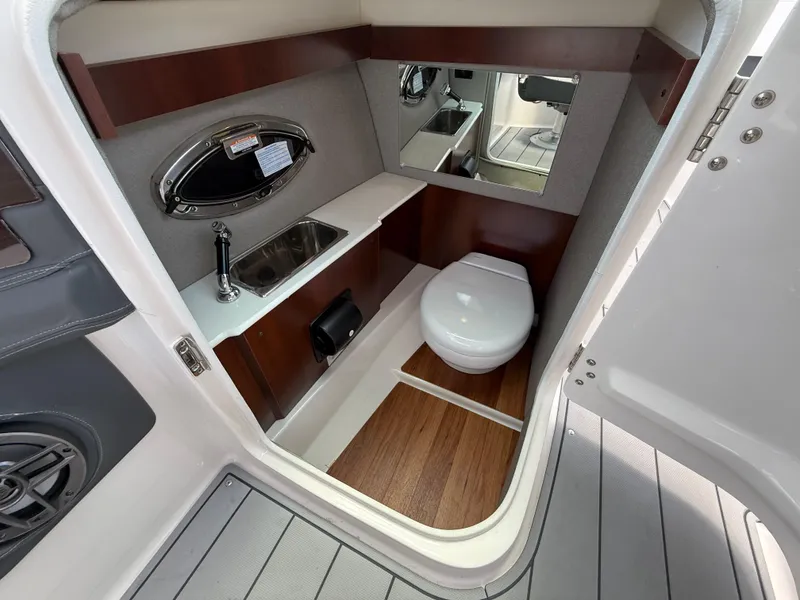 Slide: The Image of 2022 Chaparral 267 SSX OB boat interior with compact bathroom and sink. - 32