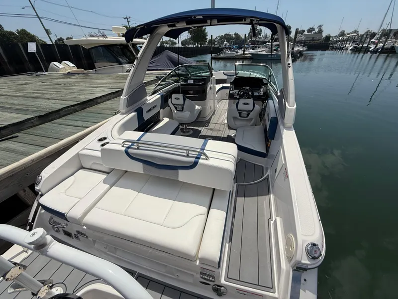 Slide: The Image of 2022 Chaparral 267 SSX OB boat docked at marina, featuring spacious seating and modern design. - 6