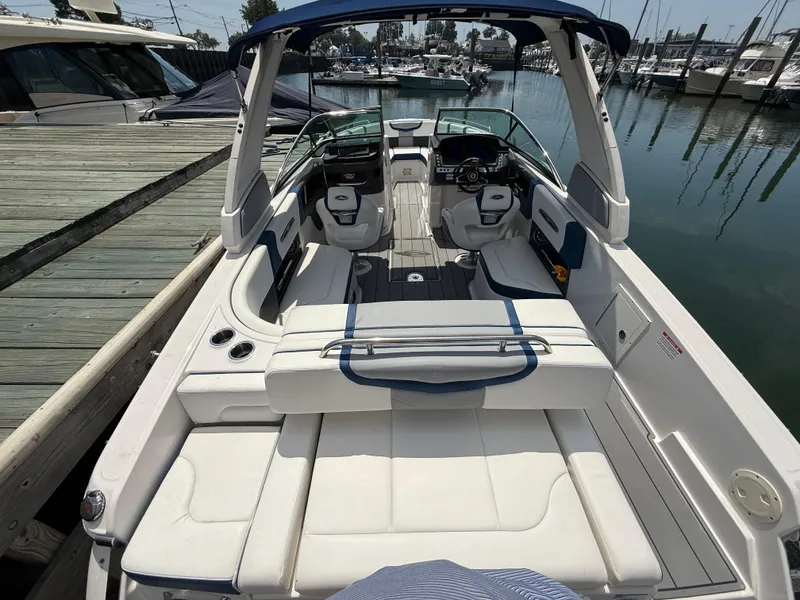 Slide: The Image of 2022 Chaparral 267 SSX OB boat interior at marina, featuring spacious seating and modern design. - 8