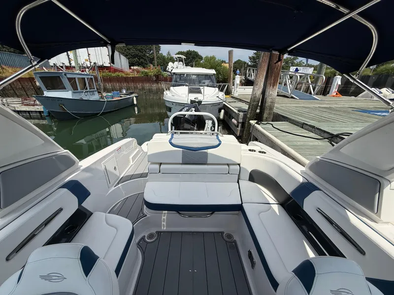 Slide: The Image of 2022 Chaparral 267 SSX OB boat interior at dock, featuring spacious seating and sleek design. - 9