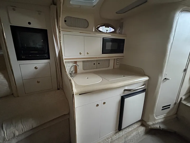 Slide: The Image of Interior of 2000 Sea Ray 290 Sundancer with kitchenette, microwave, and compact fridge. - 10