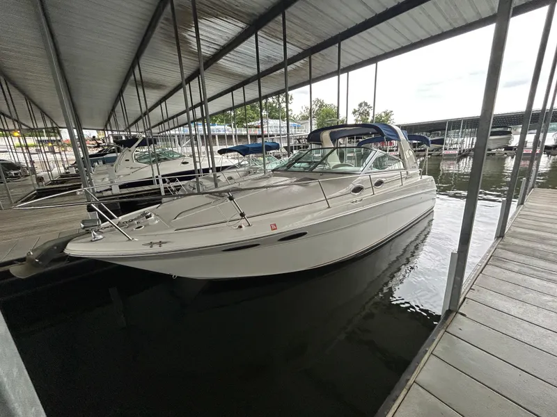 Slide: The Image of 2000 Sea Ray 290 Sundancer docked in a covered marina, side view. - 4