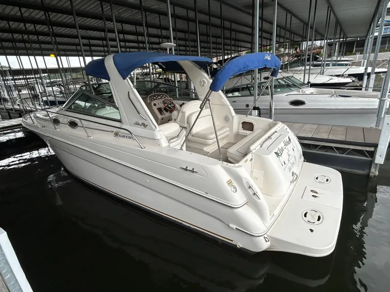 Slide: The Image of 2000 Sea Ray 290 Sundancer docked in a covered marina, featuring a blue canopy. - 5
