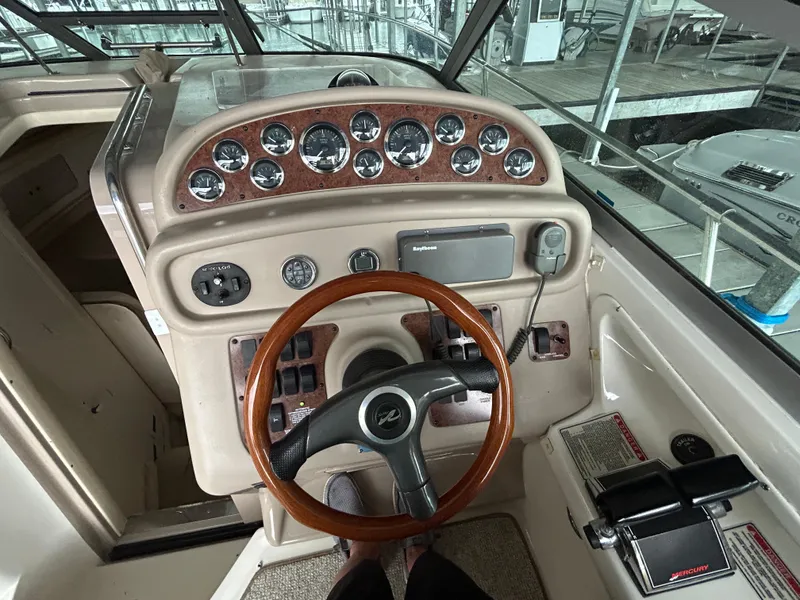 Slide: The Image of Helm of 2000 Sea Ray 290 Sundancer with wood-accented steering and instrument panel. - 7